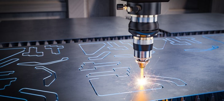 A close-up of a laser cutting head in use, emitting bright sparks while cutting a large sheet of metal with intricate cutouts.